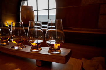 Flight of single malt scotch whisky in glasses served in whiskey bar in Edinburgh, UK