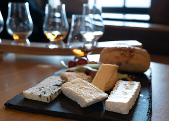 Pairing of scotch whisky and farmers scottish cheeses cheddar, stilton, blue cheese, brie, tasting of whiskey and cheese in Edinburgh, UK