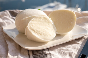 Tasting of white soft italian balls mozzarella cheese made from buffalo cow milk