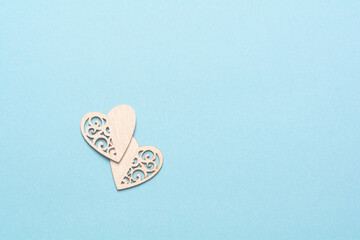 Two wooden hearts on a blue background. Background for the holiday of Valentine's Day. The concept of love, romance and tenderness