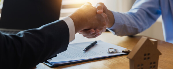 Close up handshake of real estate  customer with agent after success signing contract