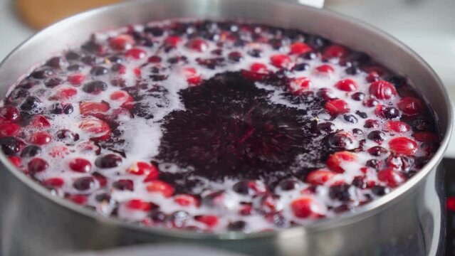 Boiled cherries and black currants, the cooking process. Boiling berries. Selective focus