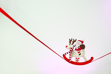 Minimalistic Christmas card. Christmas tree toy wooden Santa Claus on a deer on a red ribbon. Happy New Year 2023. Merry Christmas greetings. Santa Claus is coming