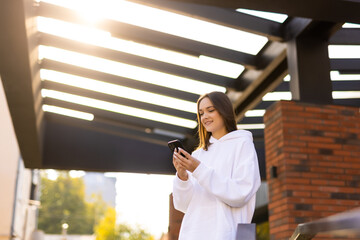 Portrait of pretty cheerful girl use telephone chatting gps route navigation stroll street