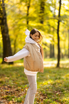 season and people concept. beautiful happy young woman having fun with leaves in autumn park