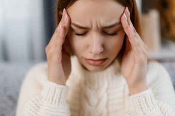 Woman on couch suffering from migraine