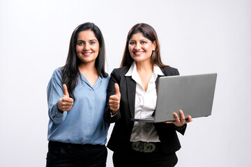 Two young indian business woman or employee showing thumps up with laptop