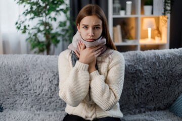 Sick woman in scarf on couch