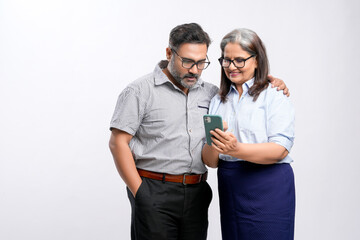 senior female businesswomen or executive showing detail in smartphone to his colleague.