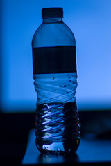 transparent plastic bottle of water on dark studio light