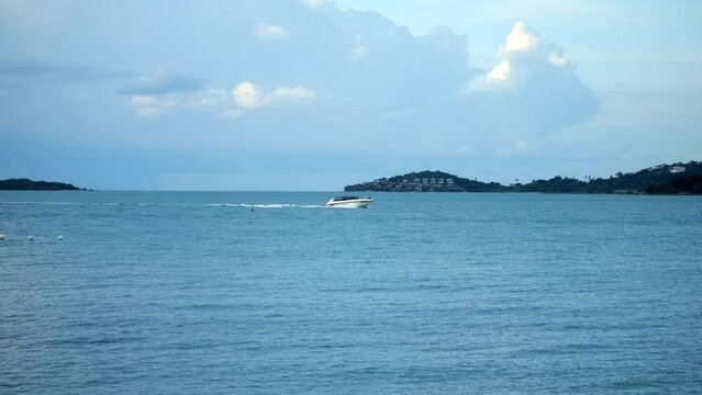 Beautiful tropical beach with blue sky and white cloud, mountains background. Sailing boats on the blue sea. Summer vacation. Nature environment concept. Tourism and travel