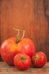 branch of tomatoes on a dark wood background