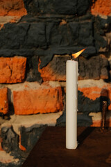 Candle flame on brick wall background. Copy space.