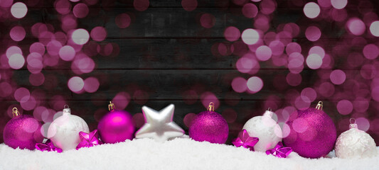 Festive christmas ornaments advent celebration holiday holidays banner greeting card - Pink and white christmas baubles, christmas balls on snow, with black wooden wall and bokeh lights background