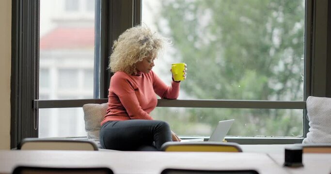 Woman relaxing by window in office