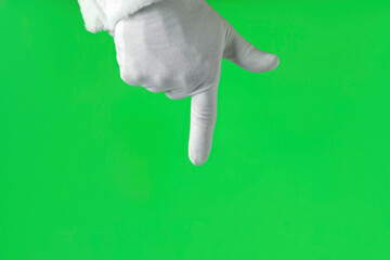 Santa Claus Hand Pointing at Something with Index Finger Isolated On Green Background. Close Up. White Gloved Hand Points Down with one finger. Chroma Key Screen. Advertisement gesture.