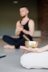 Selective focus. Practice of standing on nails. Couple of person meditation before stand on sadhu board with TIBETAN BOWLS. Concept on healthy lifestyle.