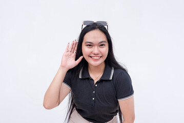 A friendly asian woman requesting to listen on the latest gossip. Hand gesture on ear. Isolated on a white background.