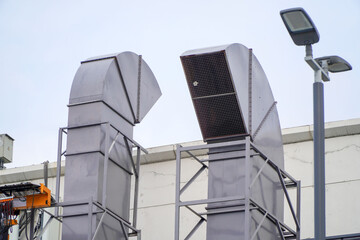 shopping center's large ventilation system includes a grill duct and a vacuum venting fan at the top of the building.