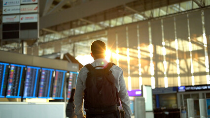 Man traveler with protective mask walking at airport terminal.