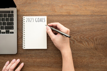 Man is writing 2023 goals for new year resolutions plan.