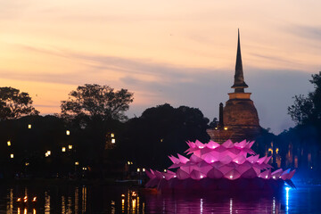 Fototapeta premium Thai temple and giant Krathong in the evening, wat mahathat, sukhothai, Loy Kratong Festival, old city of sukhothai Thailand 