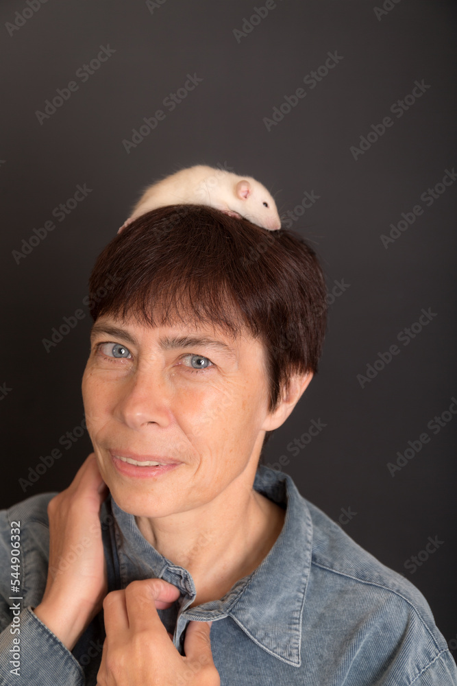 Wall mural studio portrait of woman with white baby rat