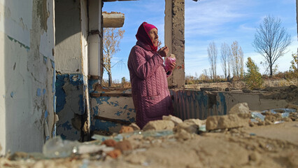 An old grandmother in prayer. Prayer for Ukraine. Grandmother prays for an end to the war. War in...