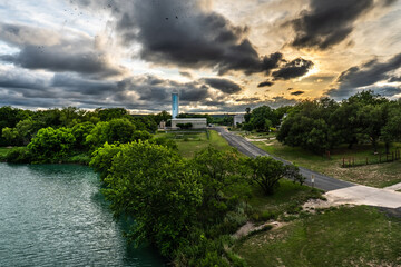 A water plant by a river and a rural road in a tree filled scenery. Junction, Texas