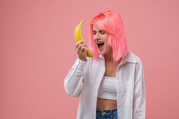 Modern young woman performing a song with a fruit mike