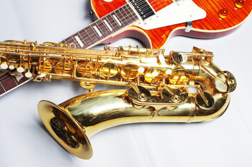 Obraz na płótnie Canvas Electric guitar and golden saxophone on a light background.