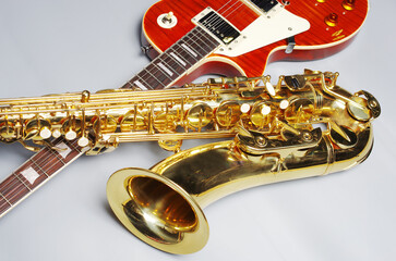 Electric guitar and golden saxophone on a light background.