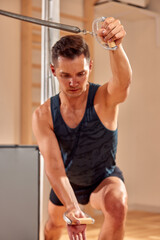 Fototapeta na wymiar Pilates reformer workout exercises man at gym indoor.