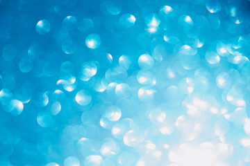 Shiny light blue blurred background for holiday design. Christmas abstract textured glitter, selective focus