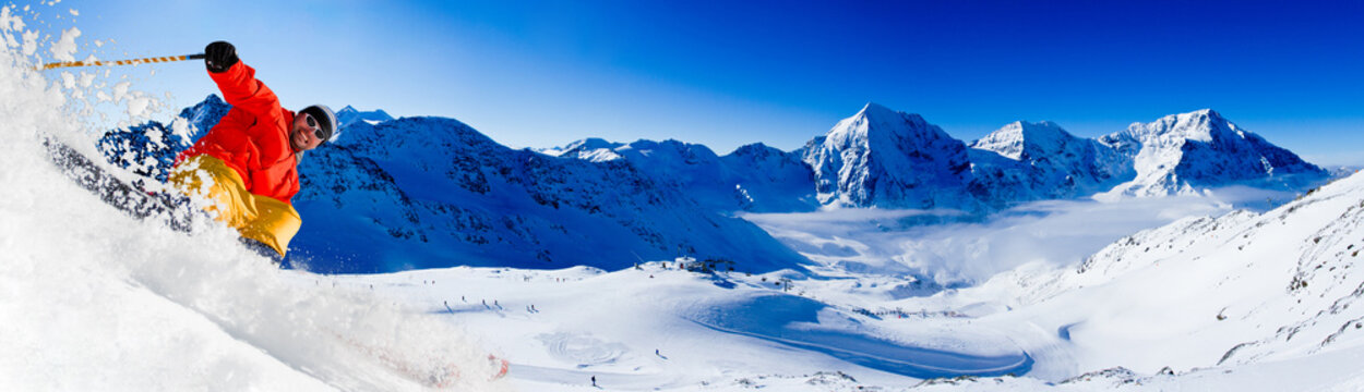 Man skiing in fresh powder snow at sunny day in Alps, Italy