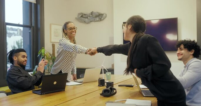 Business women shaking hands during meeting in creative office