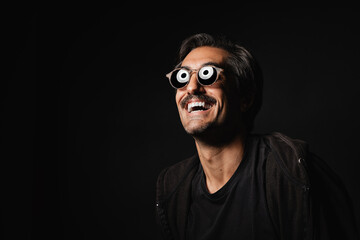Obraz premium smiling man looks at the flash in the studio and reflects the light on sunglasses
