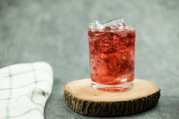 Sparkling red water soda with ice cubes. Summer iced drink, homemade summer drink.