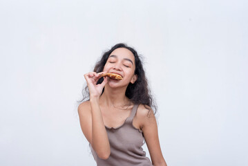 Fototapeta premium A young asian woman savors the taste of a sweet chili chicken wing. Isolated on a light background.
