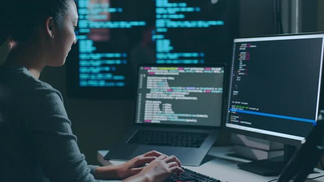 Young Asian woman, developer programmer, software engineer, IT support, working hard at night overtime on computer to check coding in bugging system