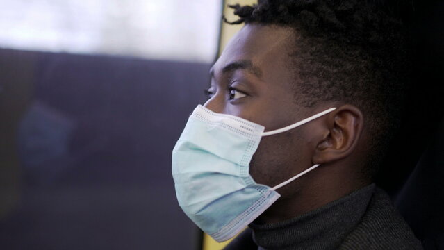 Black Man Commuter Inside Subway Metro Looking Out Window Wearing Covid-19 Face Mask