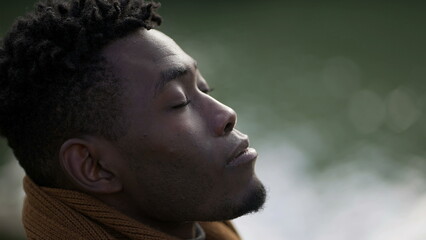 Black man closing and opening eyes in contemplation and meditation