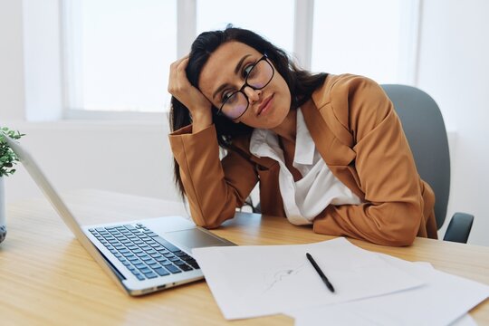 Woman business works in the office at the desk falls asleep at work, autumn depression, vitamin deficiency, fatigue at work
