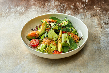 Salad with avocado and salmon in a plate. Close-up, selective focus