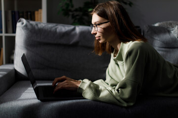 Woman typing on laptop on couch