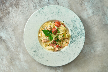 Pasta with salmon and vegetables in a plate. Selective focus, close-up