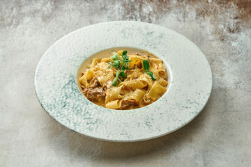 Pasta with veal and parmesan in a plate. Close-up, selective focus.