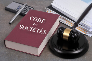 Livre du code des sociétés avec un marteau de juge