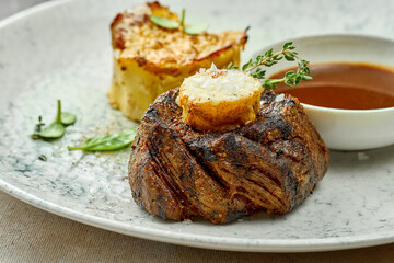 Filet mignon steak with mashed potatoes and sauce in a plate. Close-up, selective focus.