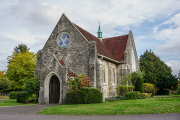 Fototapeta na wymiar pretty small chapel in picturesque setting. Religious building exterior. Quaint English church façade 